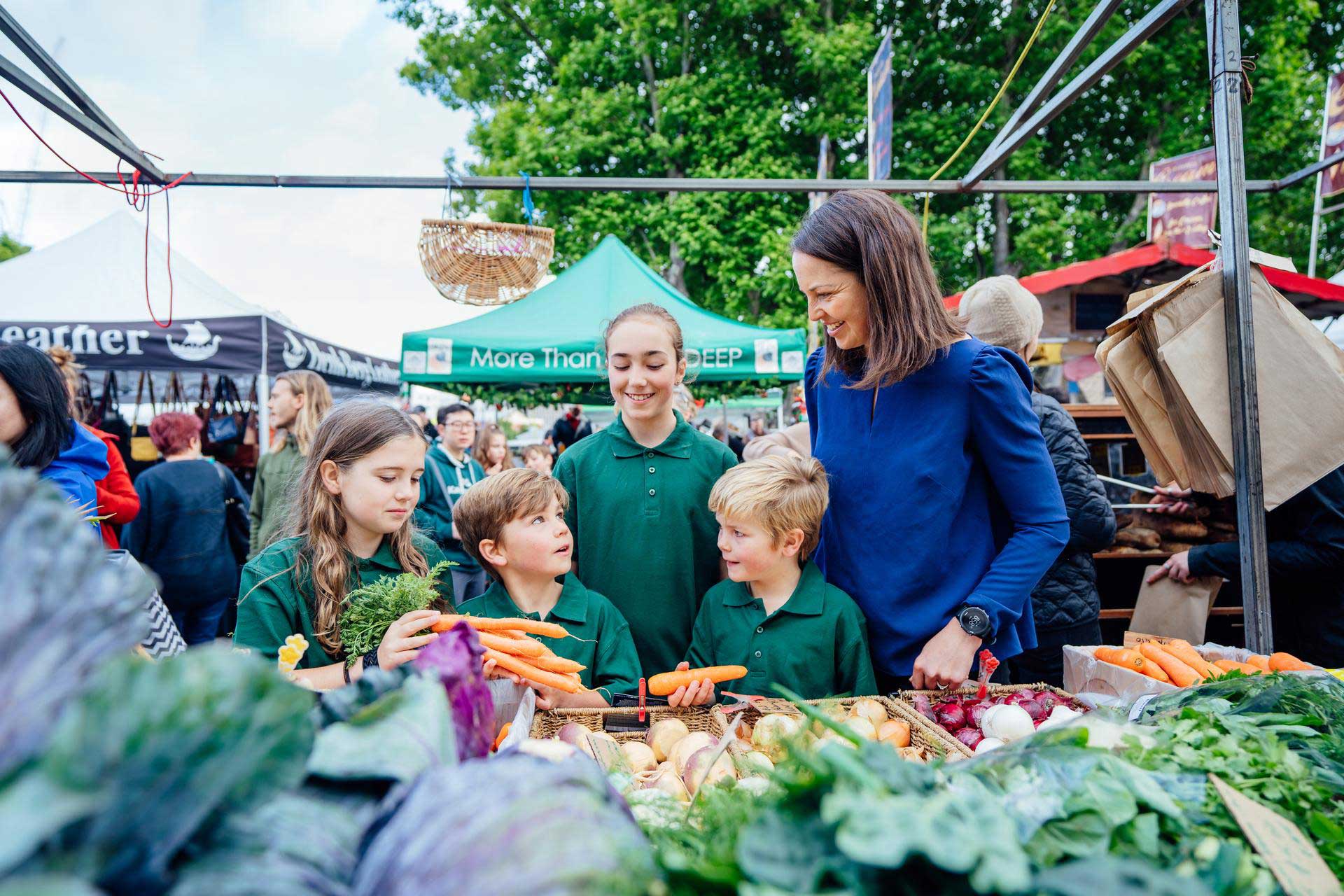 Young students at fresh fruit and vegetable stall