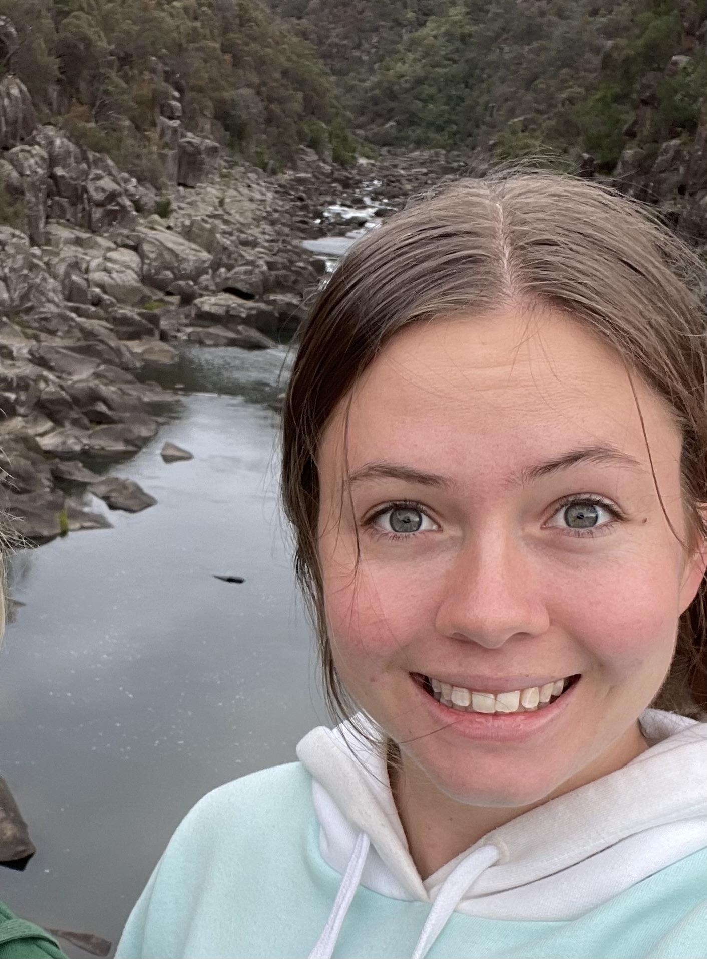 Selfie portrait of Maritime Engineering student Cameron Skeggs smiling with the distinctive rocky cliffs and water of Launceston's Gorge in the background.