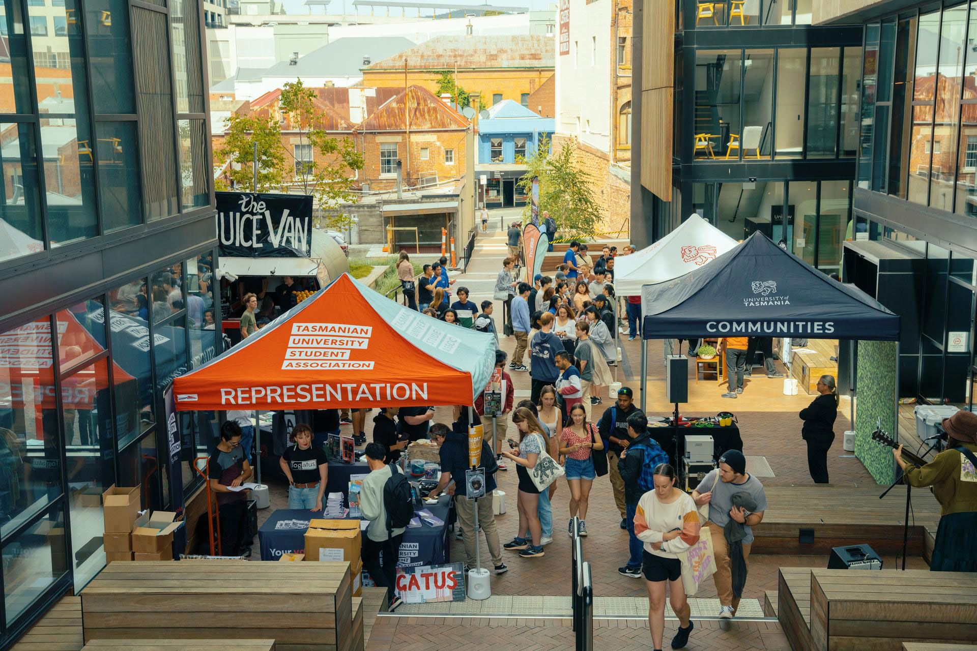 Students enjoying music and infomation marquees outside Podium Building during O week.